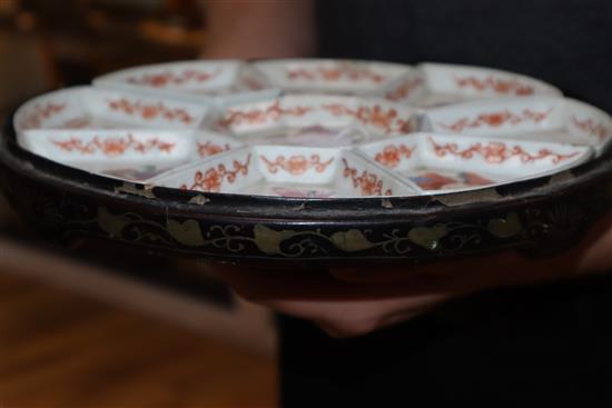 A 19th century Chinese famille rose immortals supper dish set, lacquer base only.